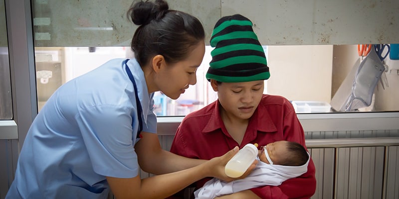 Nurse Feeding The Baby